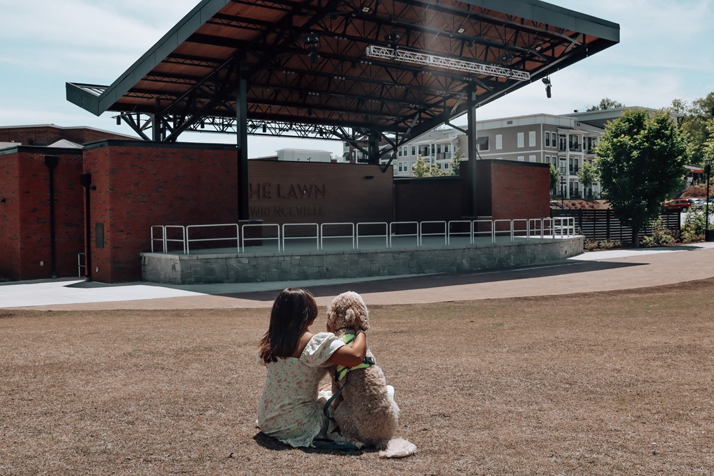 a girl and her dog sitting in front of a bandstand at The Wren Apartments, Lawrenceville, Georgia