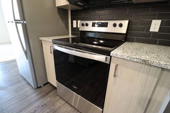 a kitchen with a stove top oven next to a refrigerator at The Crest at Acworth, Acworth, 30102