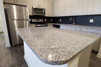 an island with granite countertop in a kitchen at The Crest at Acworth, Georgia, 30102