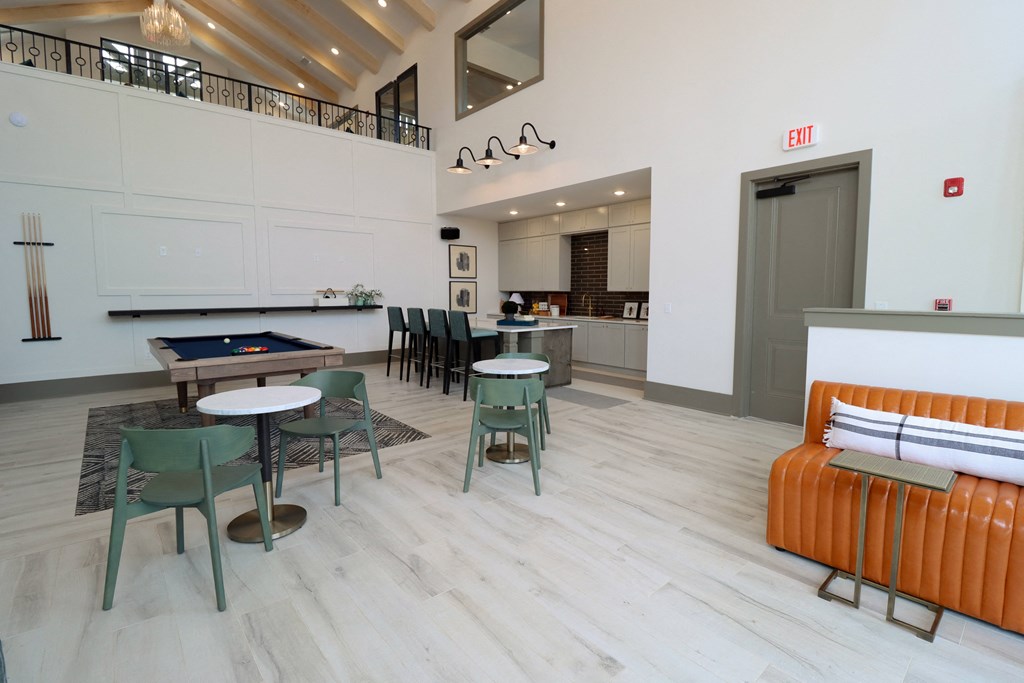 a seating area with tables and chairs and a pool table in the center of the room at The Crest at Acworth, Acworth, GA