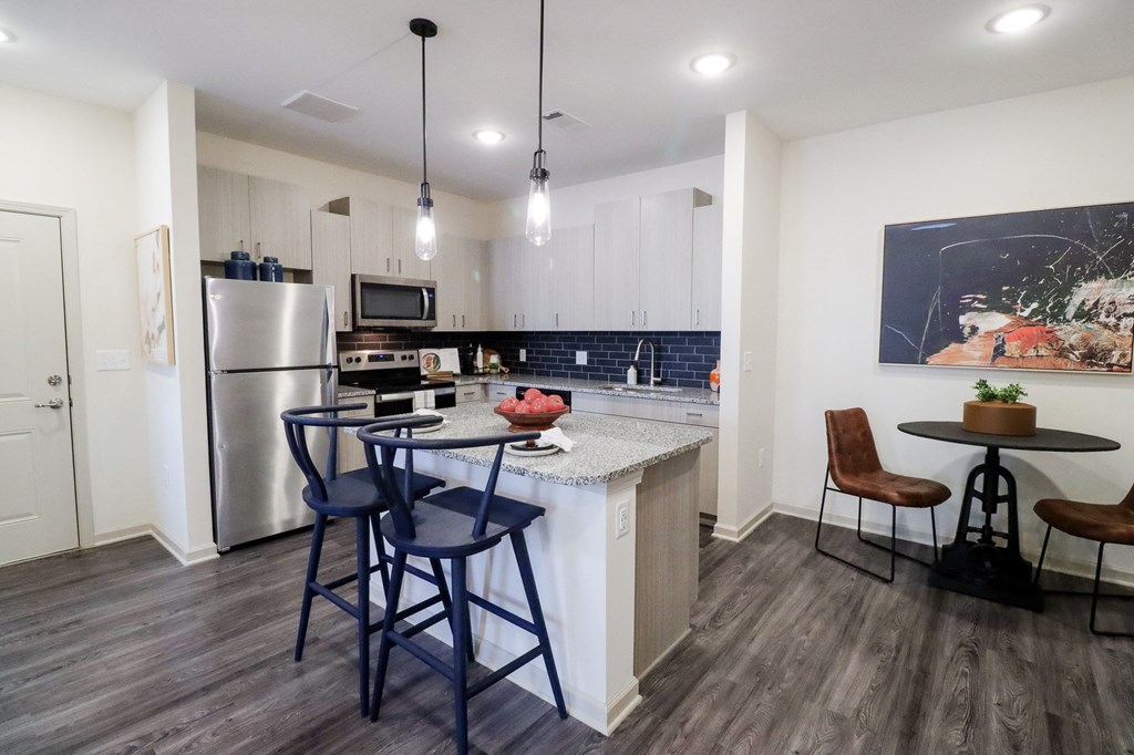 a kitchen with a bar and stools in front of a counter with a sink at The Crest at Acworth, Acworth