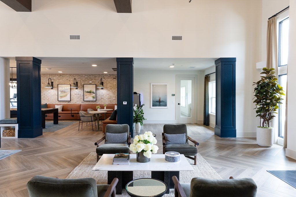 A large, modern living room with a long table and chairs. at The Crest at Oakwood Apartments, Oakwood , GA, 30566