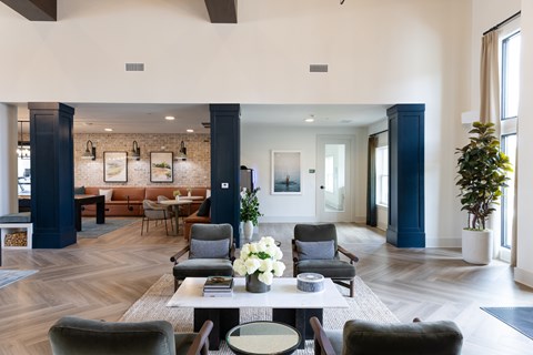 A large, modern living room with a long table and chairs.