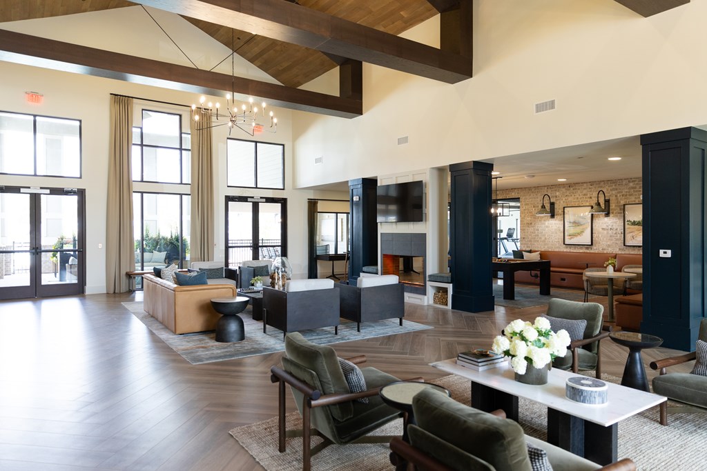 A large, open living room with wooden floors and furniture. at The Crest at Oakwood Apartments, Georgia