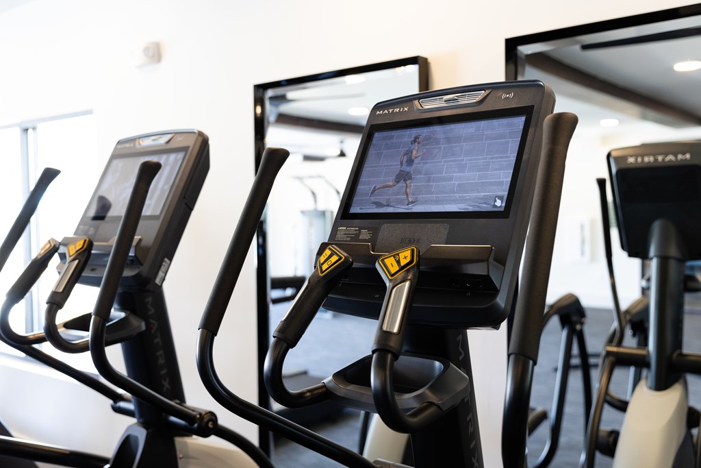 A row of stationary bikes in a gym. at The Crest at Oakwood Apartments, Georgia, 30566