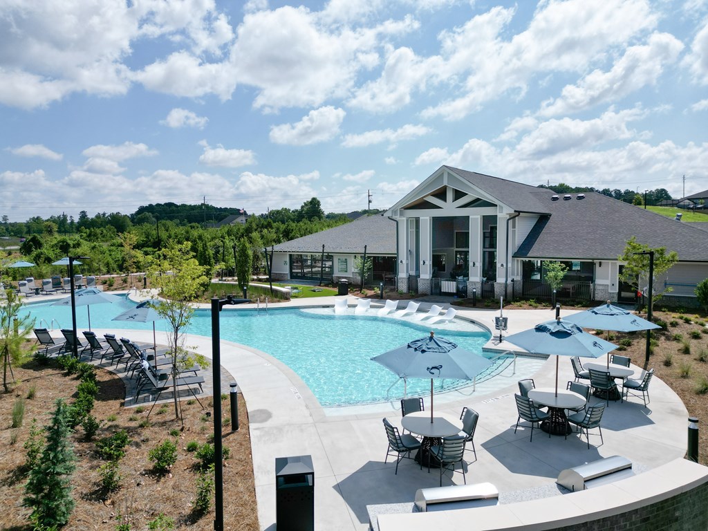A large outdoor swimming pool with a building in the background. at The Crest at Oakwood Apartments, Oakwood , Georgia