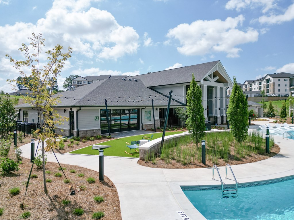 A pool area with a building in the background. at The Crest at Oakwood Apartments, Oakwood 