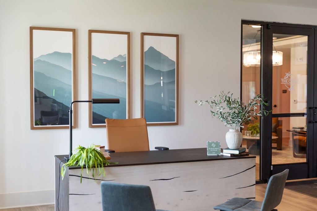 A reception desk with a chair and a plant in front of it. at The Crest at Oakwood Apartments, Oakwood  30566