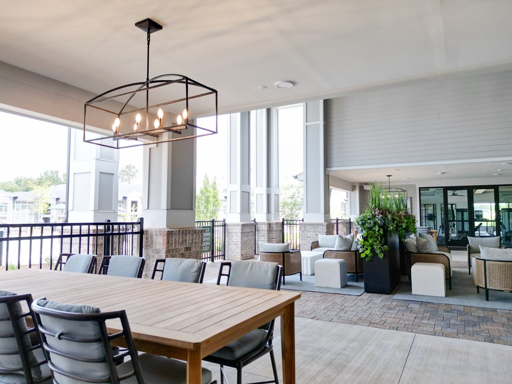 A modern dining area with a long wooden table and chairs. at The Crest at Oakwood Apartments, Oakwood , GA, 30566
