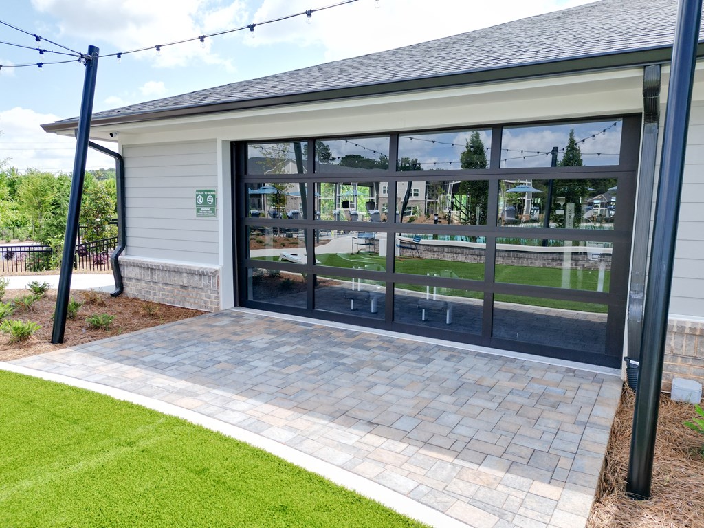 A building with a glass door and a sign on the wall. at The Crest at Oakwood Apartments, Oakwood , GA