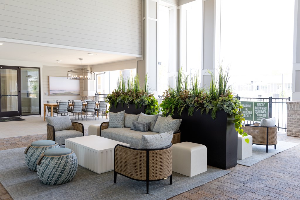 A modern outdoor seating area with a variety of furniture and plants. at The Crest at Oakwood Apartments, Oakwood  30566