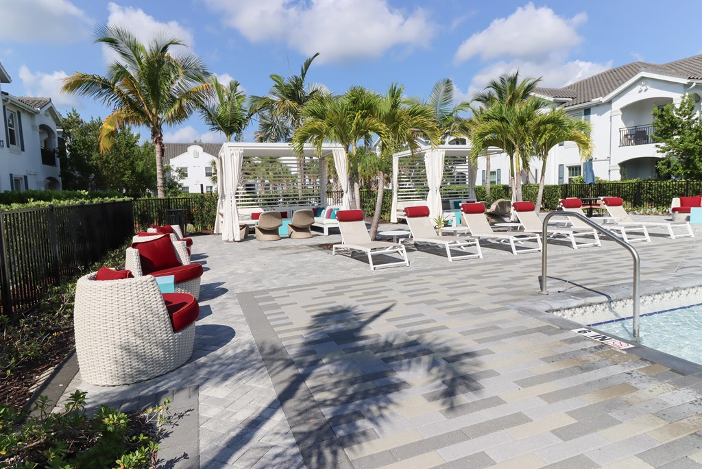 a pool with lounge chairs and palm trees