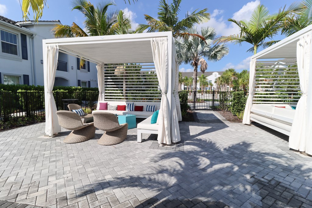a patio with two chairs and a table under a canopy