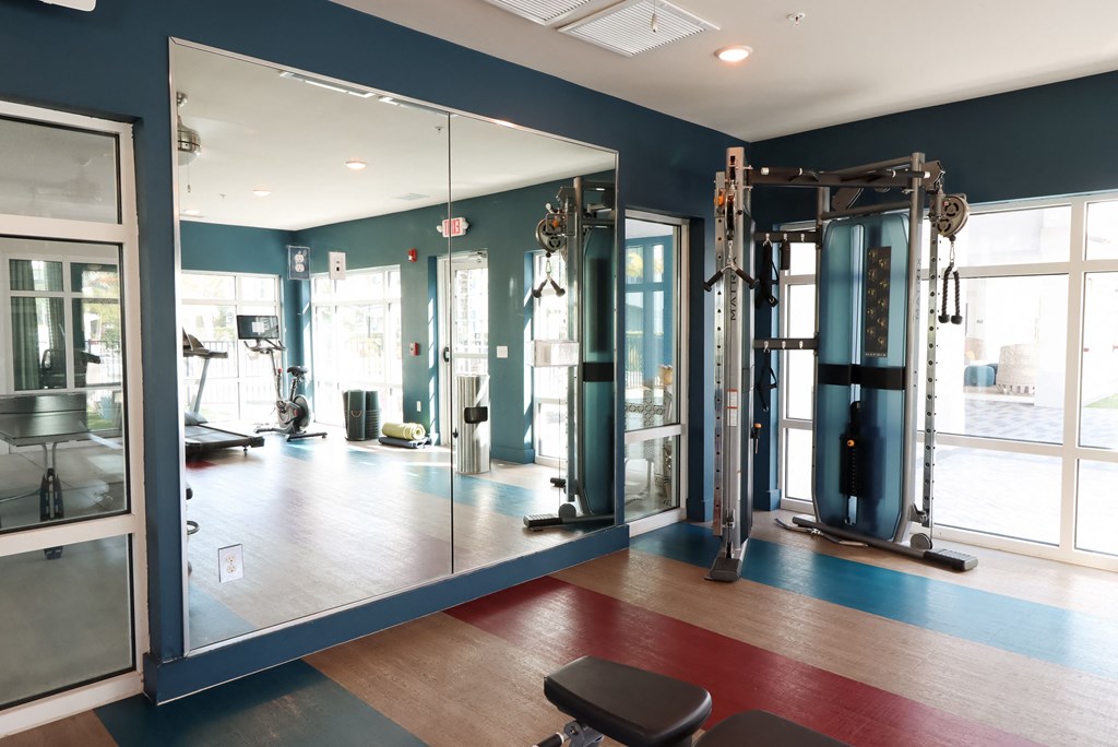 a fitness room with mirrors and exercise equipment