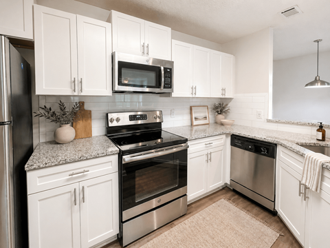A kitchen with white cabinets and stainless steel appliances.