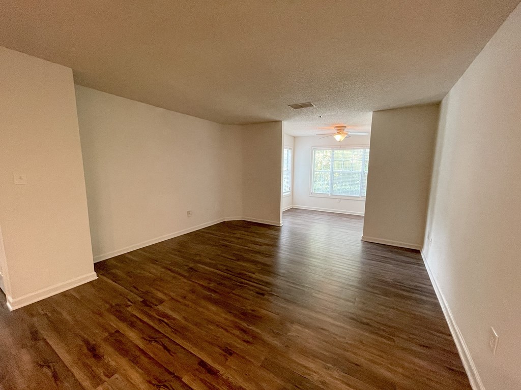 The Crest at Berkeley Lake St James renovated living space with wood style plank flooring located in Duluth, GA 30096