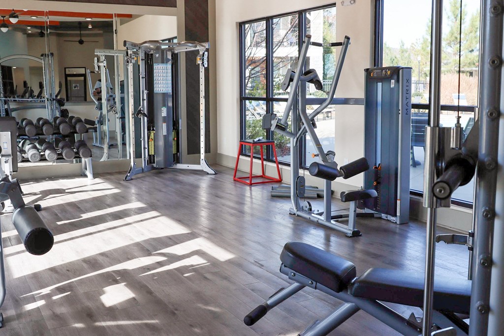 a gym with weights and cardio equipment in a building with glass doors
