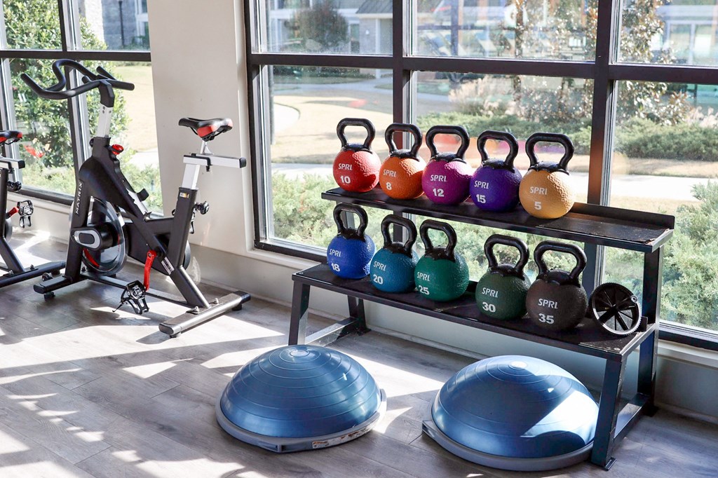 a home gym with weights and cardio equipment and a window