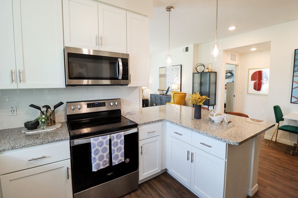 Apartment home kitchen with extended granite countertop located  at The Crest at Naples, Florida