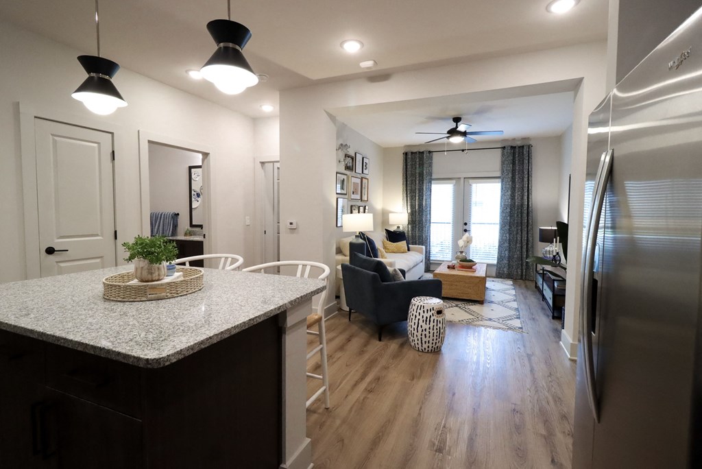 a kitchen with a counter top and a living room at The Crest at South Point Apartments, Davenport 