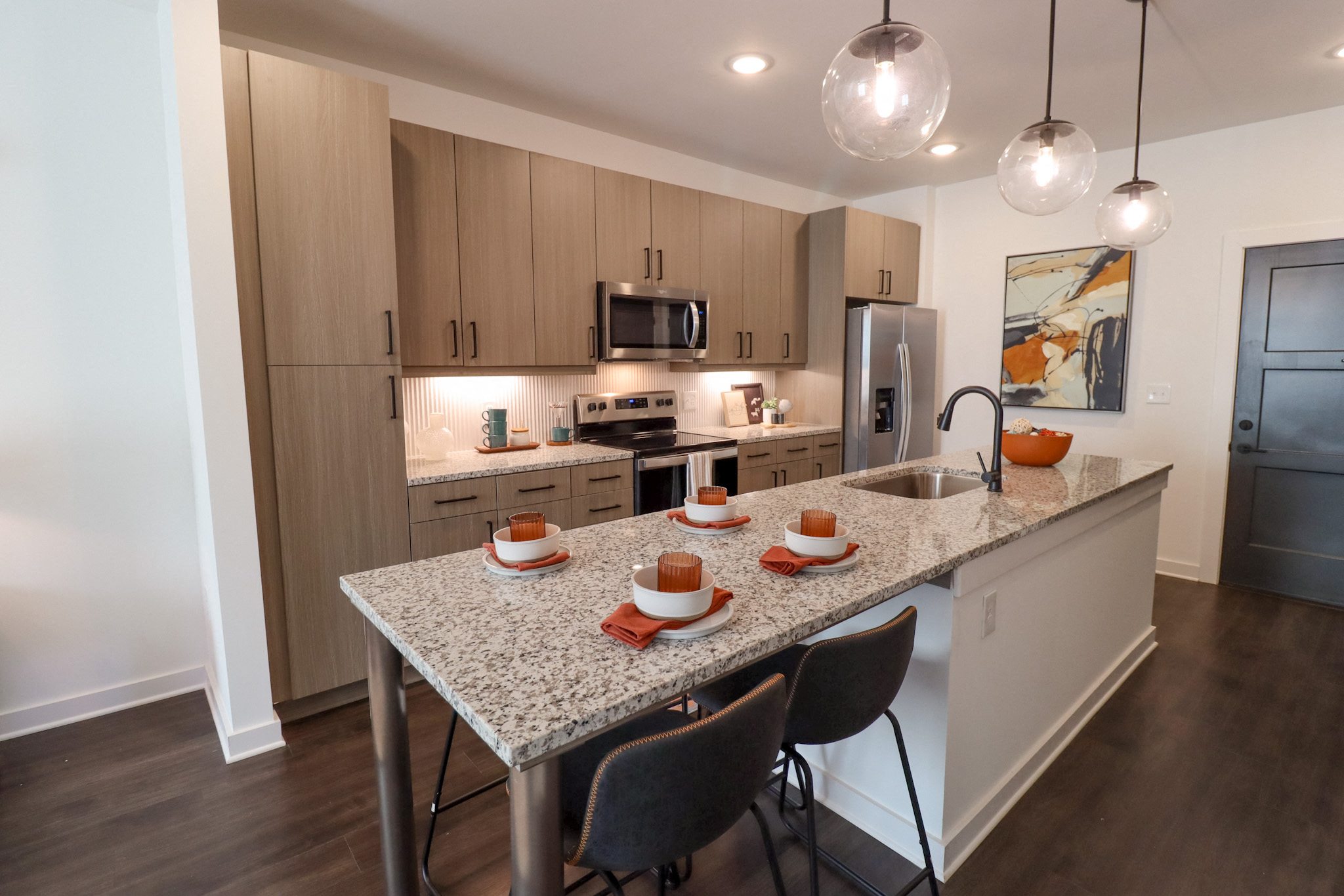 a kitchen with granite countertops and a island with plates and bowls