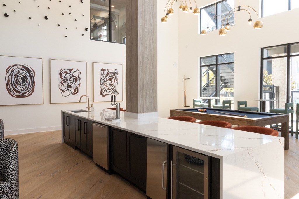 a large kitchen with a marble counter top and a pool table at The Wren Apartments, Lawrenceville, 30043