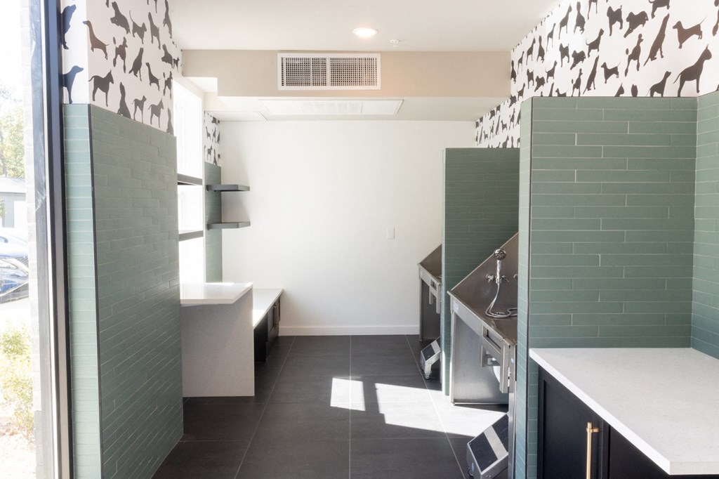 a bathroom with green tiles and a sink and a window at The Wren Apartments, Lawrenceville, GA