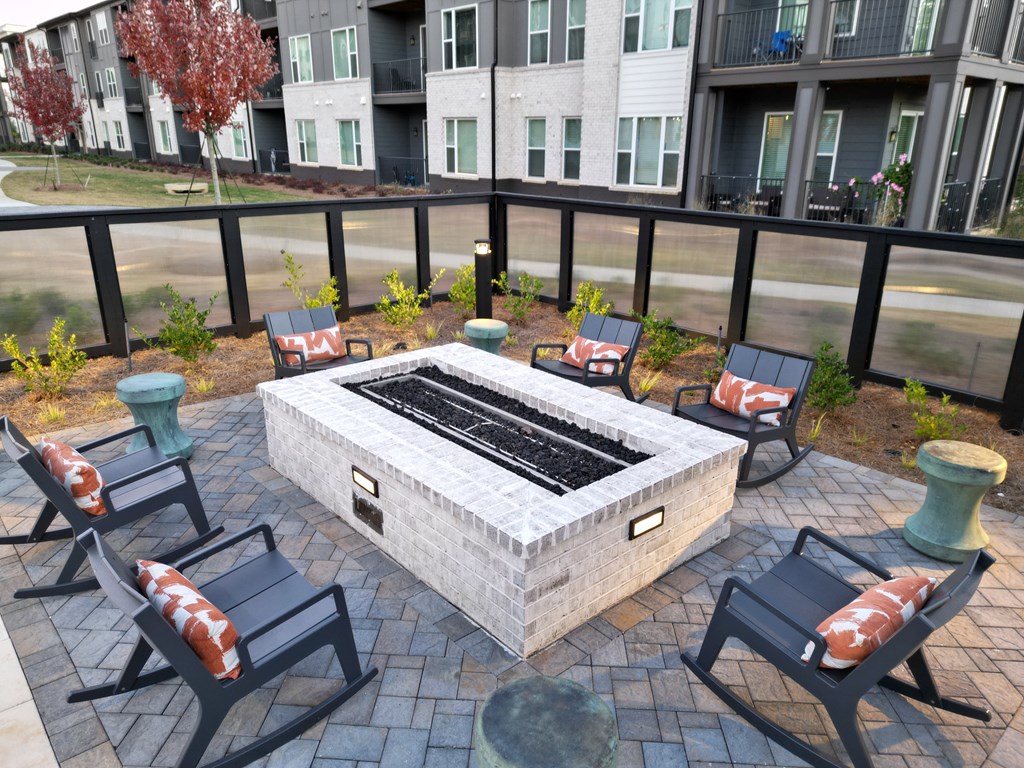 an outdoor patio with a fire pit and chairs at The Wren Apartments, Lawrenceville, Georgia