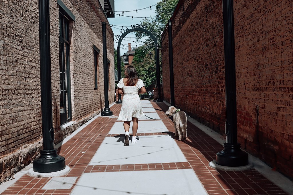 a woman running down a sidewalk with a dog at The Wren Apartments, Lawrenceville, Georgia