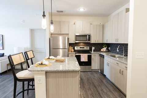 A kitchen with a table and chairs in front of it.
