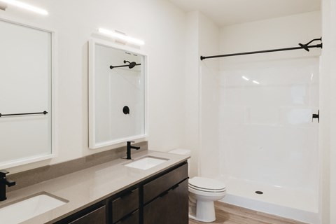 a bathroom with a large shower and a sink and a toilet