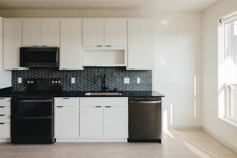 a kitchen with white cabinets and black counter tops and a black and white counter top