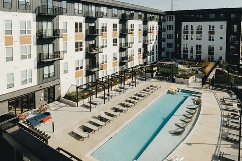 an aerial view of a swimming pool in front of an apartment building