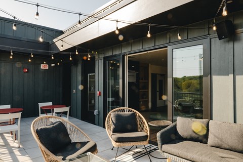 a patio with chairs and tables and sliding glass doors