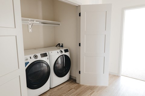 a washer and dryer in a laundry room with a white door