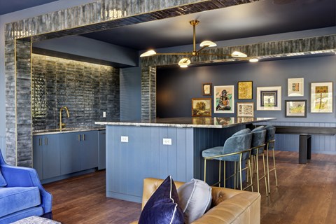 a kitchen and living room with blue cabinets and a bar