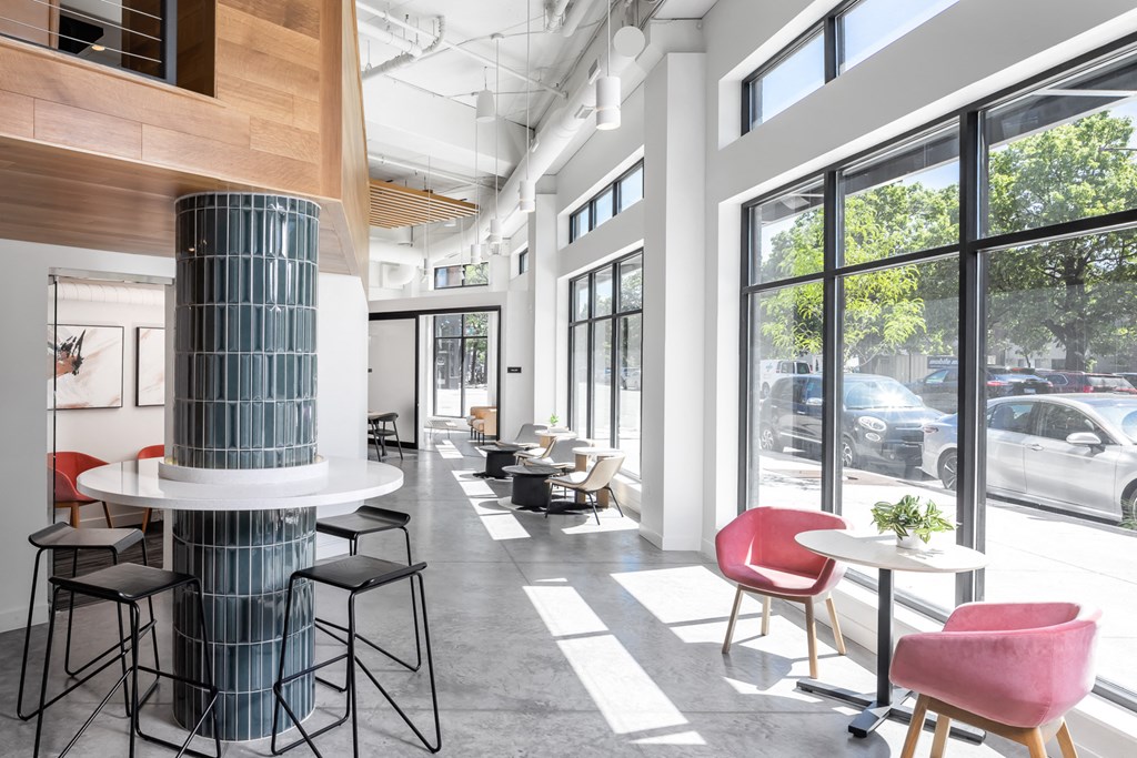 a lobby with tables and chairs and large windows