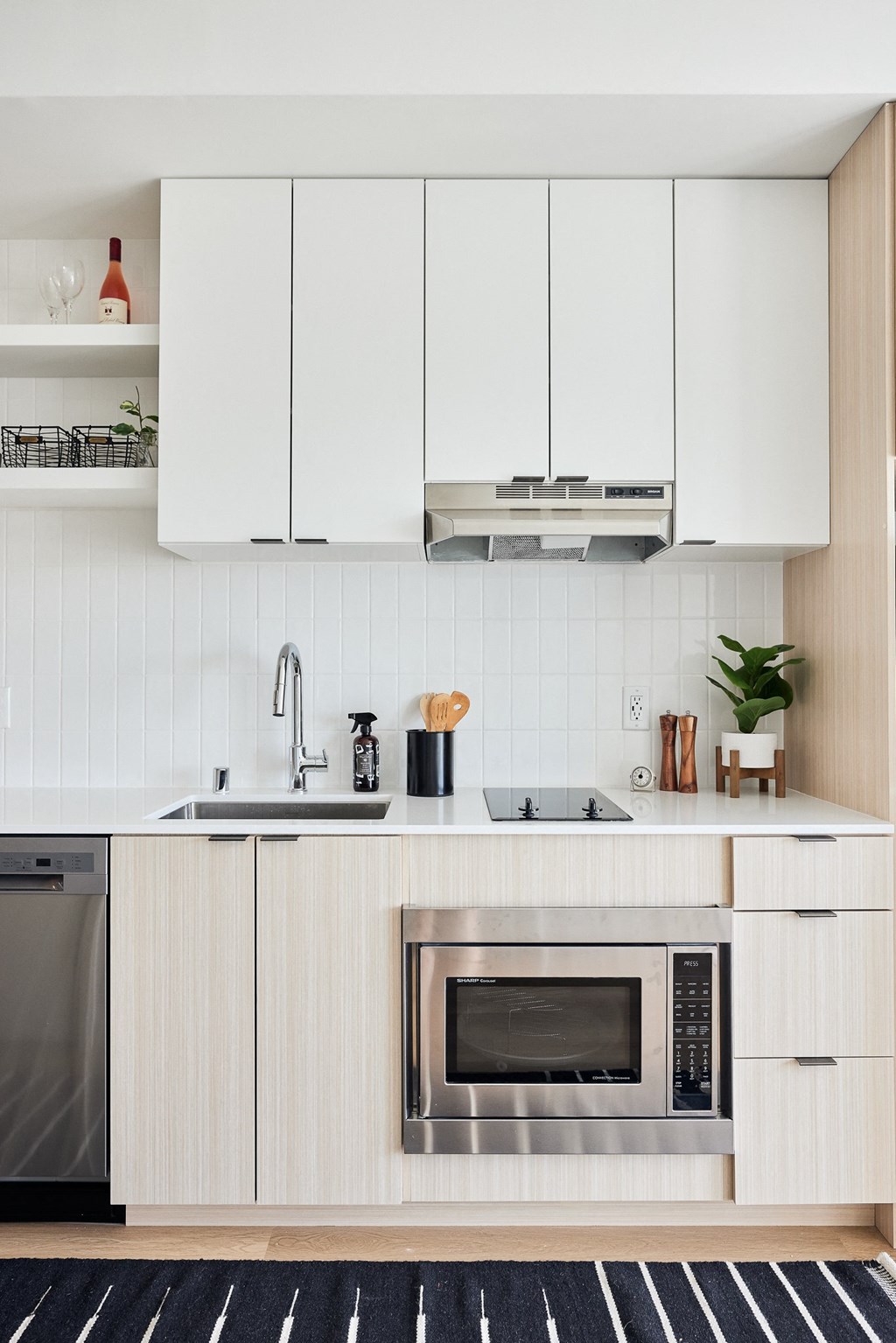a kitchen with white cabinets and a microwave and a sink