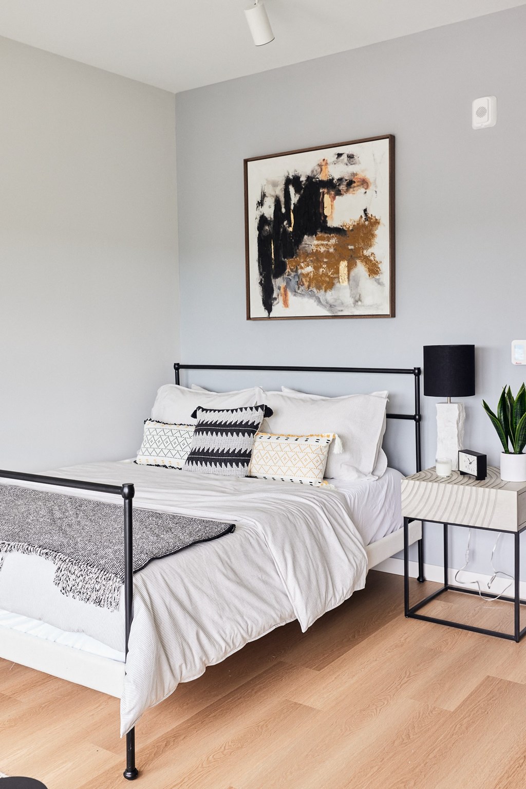 a bedroom with a bed and a painting on the wall