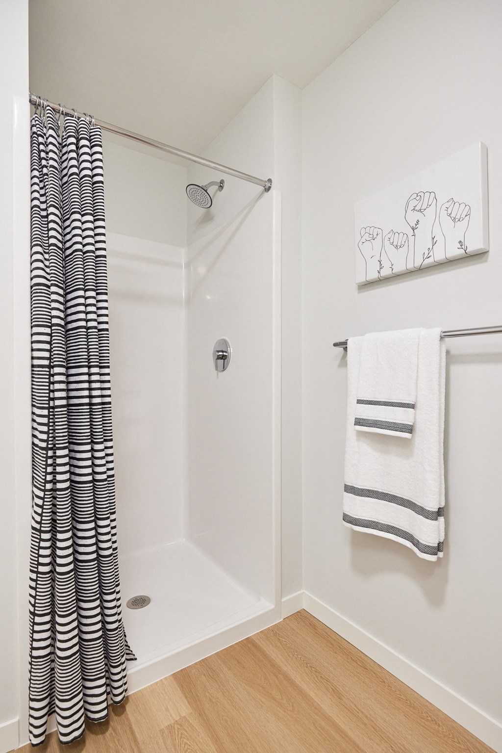 a bathroom with a shower with a black and white shower curtain
