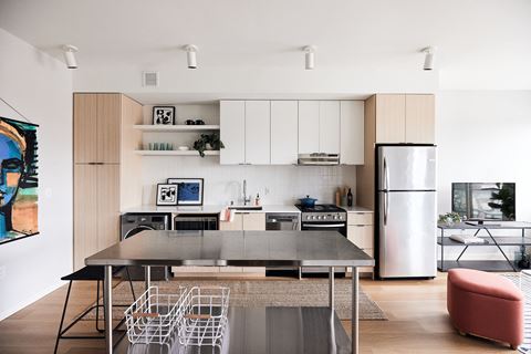 a kitchen with white cabinets and stainless steel appliances and a table and chairs