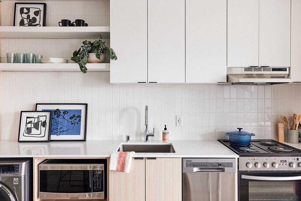 a kitchen with white cabinets and appliances and a sink