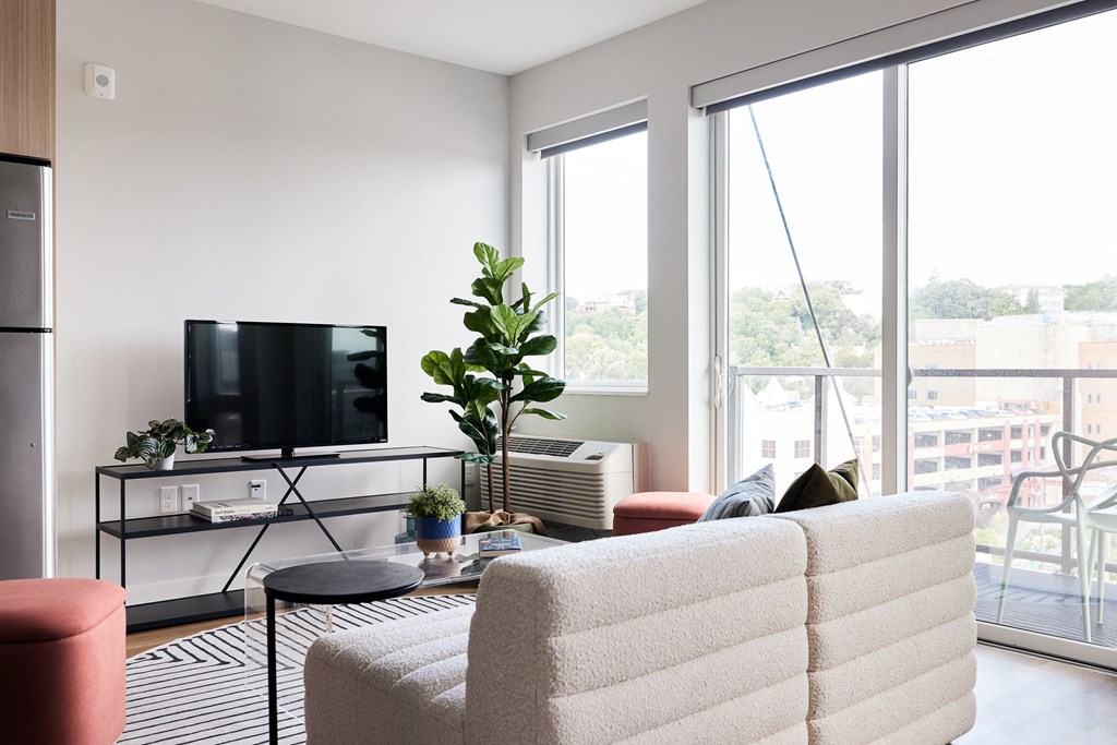 a living room with a couch and a tv and a balcony