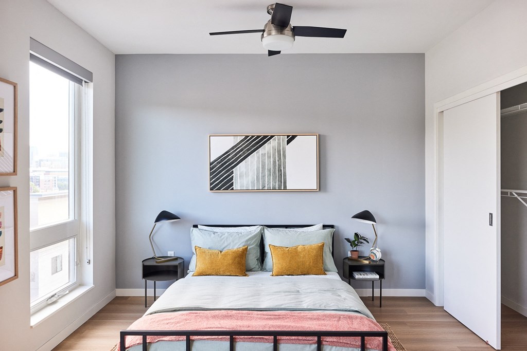 a bedroom with a bed and a ceiling fan