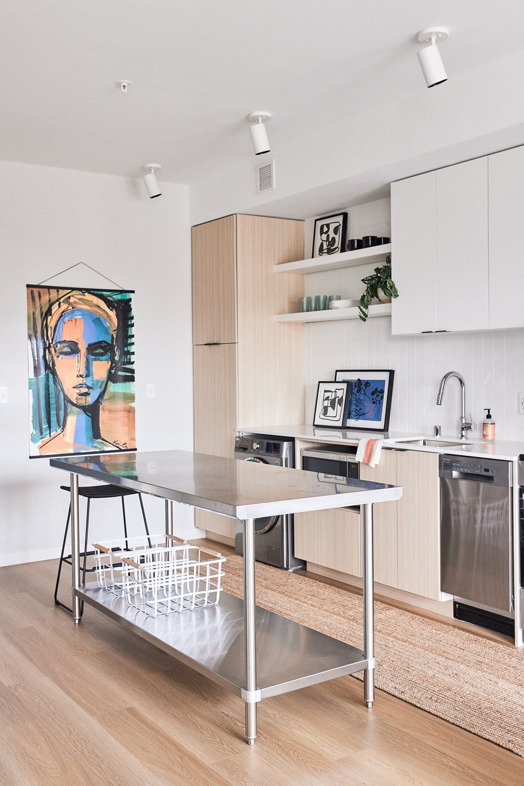 a kitchen with white cabinets and a stainless steel table