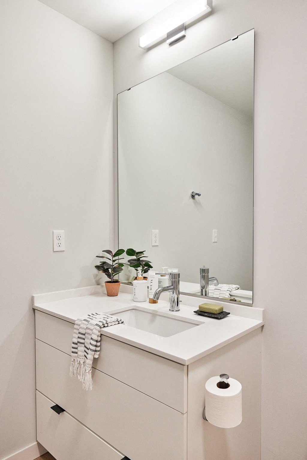 a white bathroom with a sink and a mirror