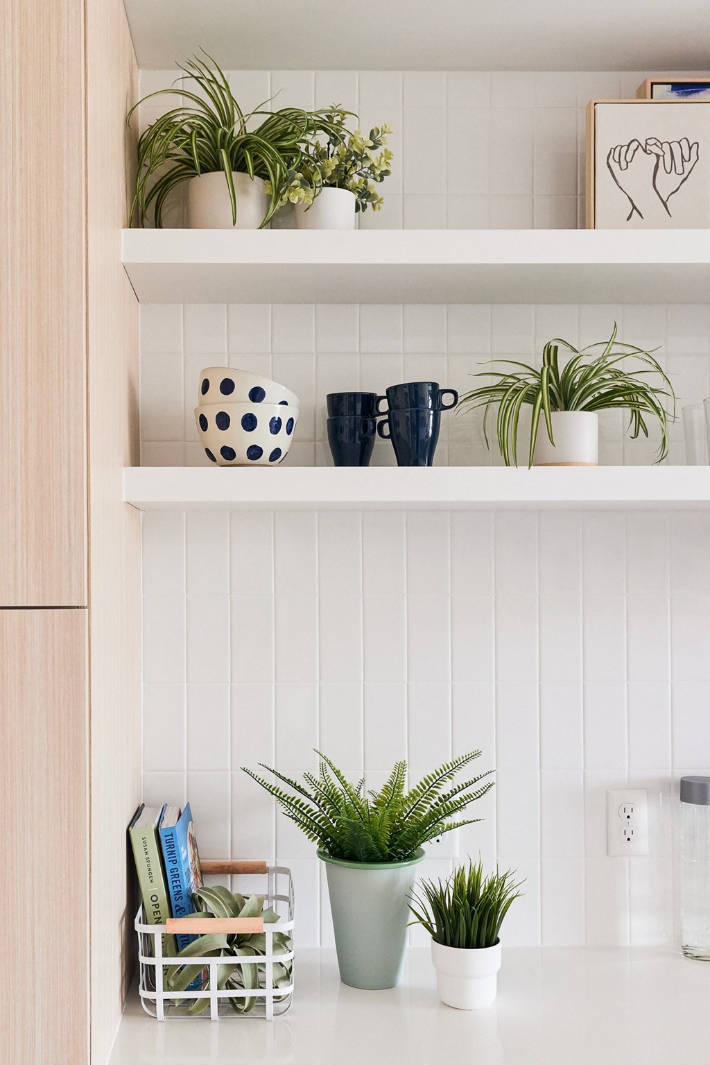 a white shelving unit with plants and pots on it