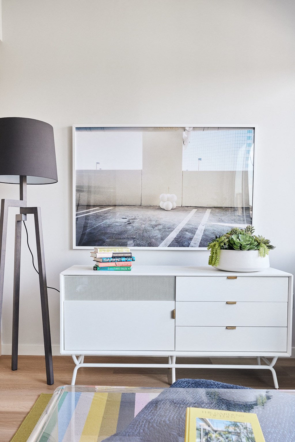 a living room with a white dresser and a tv on the wall