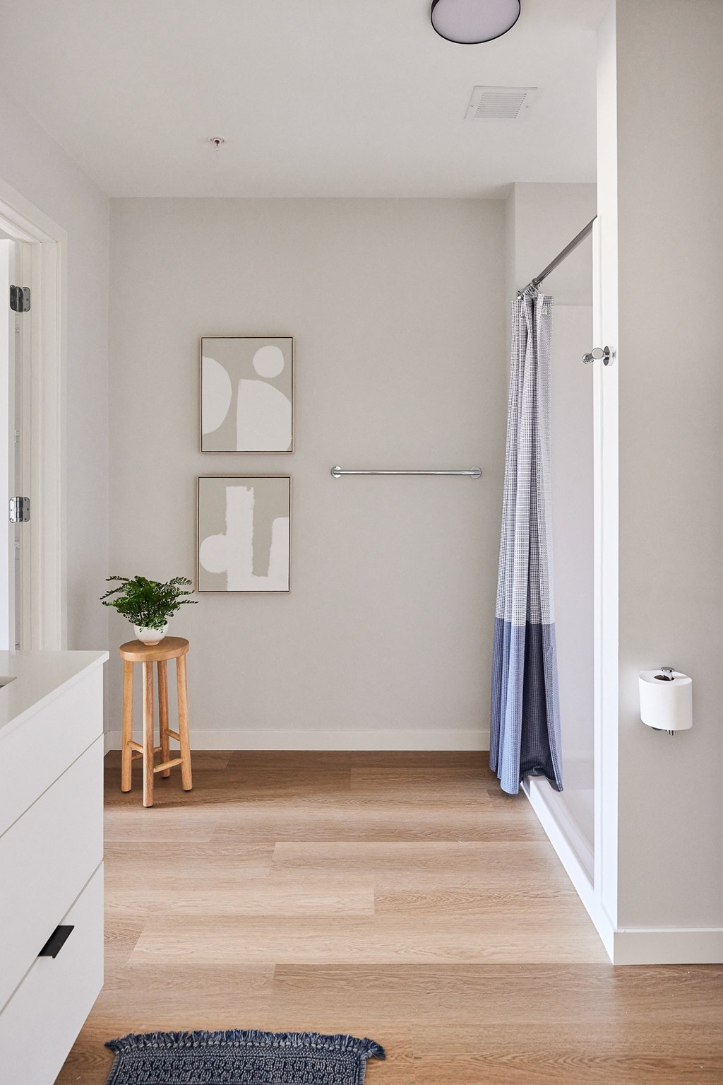 a small bathroom with a shower and a wooden floor