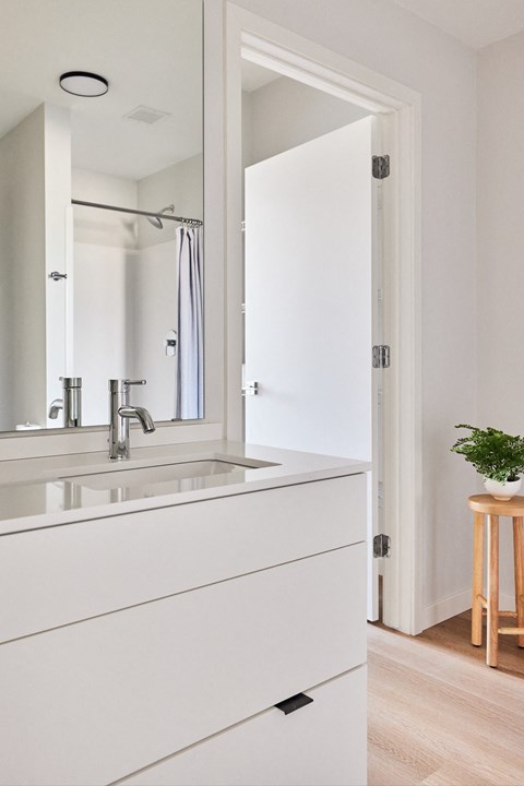 a white bathroom with a sink and a mirror